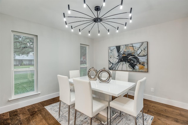 dining room with dark hardwood / wood-style floors and an inviting chandelier