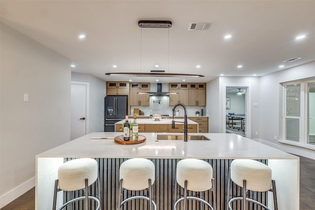 kitchen with ceiling fan, sink, a spacious island, a kitchen bar, and black fridge with ice dispenser