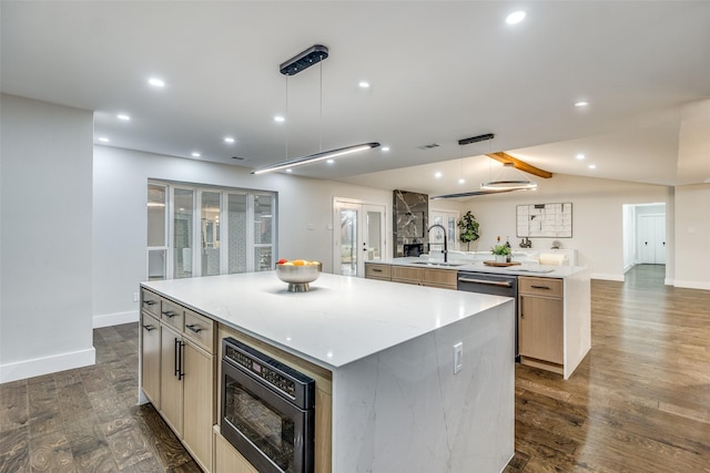 kitchen with sink, dark hardwood / wood-style flooring, a spacious island, and hanging light fixtures