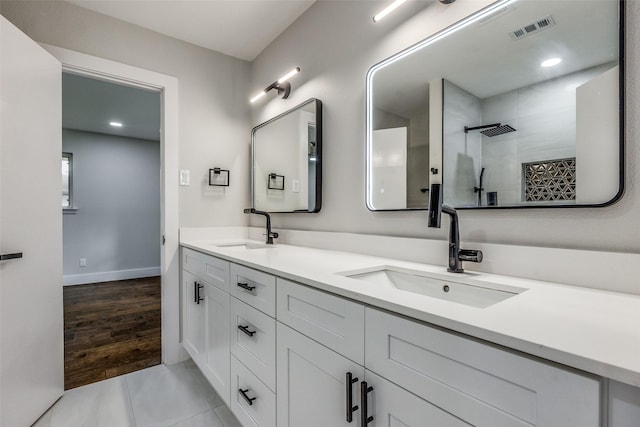 bathroom featuring tile patterned flooring, vanity, and walk in shower