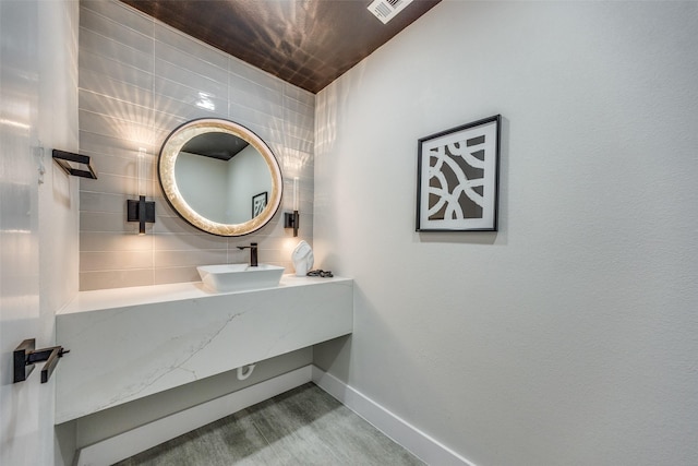 bathroom featuring vanity, wood-type flooring, and tasteful backsplash