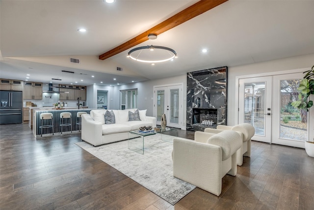 living room with french doors, lofted ceiling with beams, dark hardwood / wood-style flooring, and sink