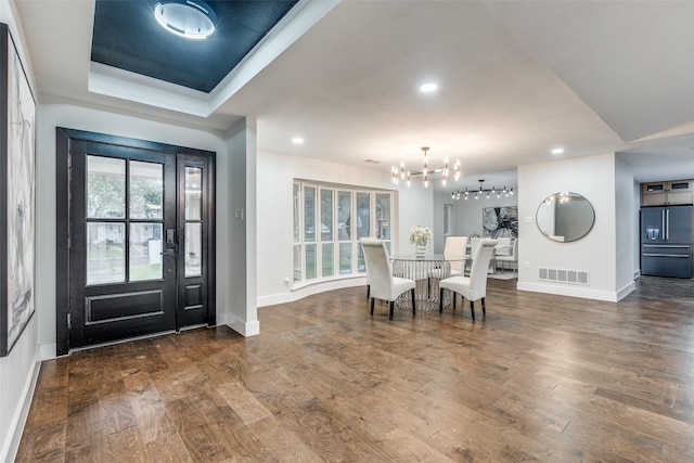 foyer entrance featuring dark wood-type flooring and a notable chandelier