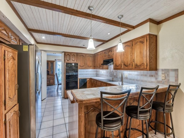 kitchen with backsplash, kitchen peninsula, wood ceiling, a kitchen bar, and black appliances