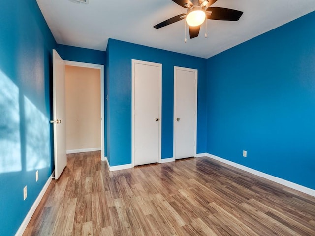 unfurnished bedroom with ceiling fan and light wood-type flooring