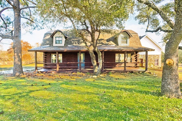 log-style house with a porch and a front yard