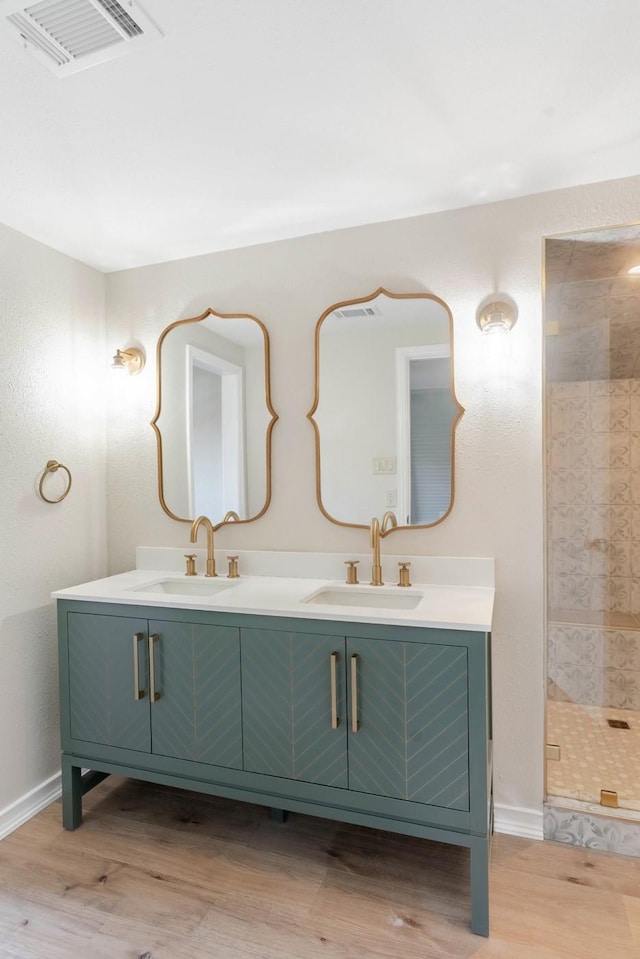 bathroom with hardwood / wood-style floors, an enclosed shower, and vanity