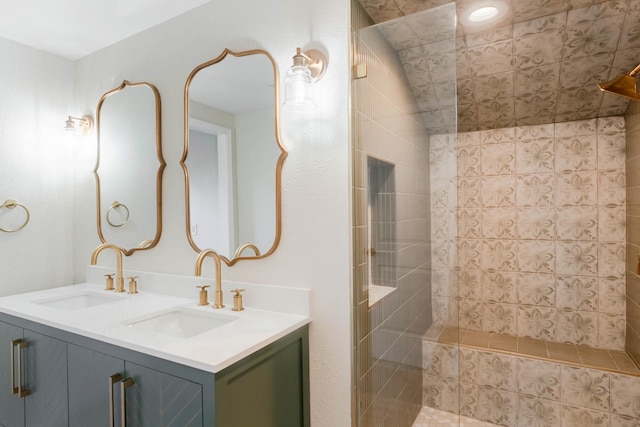 bathroom with a tile shower and vanity