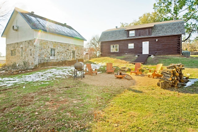 view of yard featuring central air condition unit and a fire pit