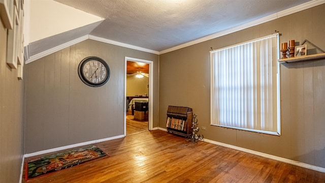 interior space with hardwood / wood-style floors, a textured ceiling, ornamental molding, and lofted ceiling