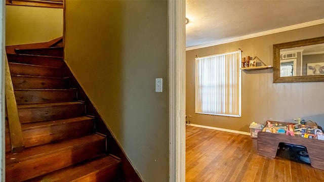 stairs featuring wood-type flooring and ornamental molding