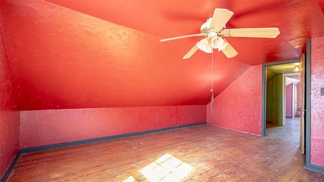 additional living space featuring hardwood / wood-style flooring, ceiling fan, and lofted ceiling