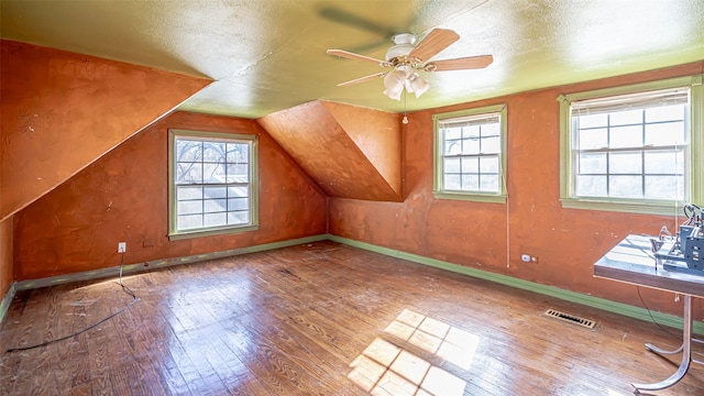 additional living space with wood-type flooring, a textured ceiling, ceiling fan, and lofted ceiling