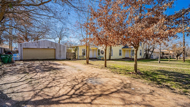 view of front of home featuring a garage, a front lawn, and an outdoor structure