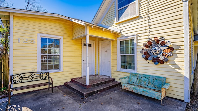 view of exterior entry with a patio area