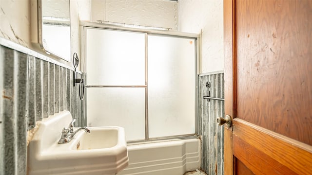 bathroom with enclosed tub / shower combo and sink