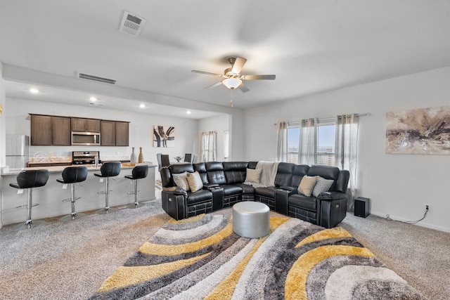 carpeted living room with ceiling fan