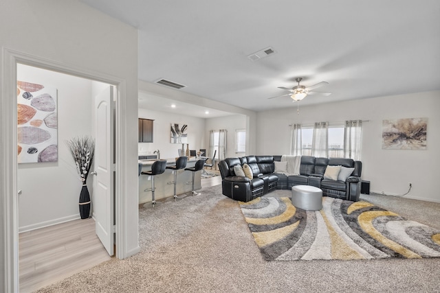 living room featuring ceiling fan and light colored carpet