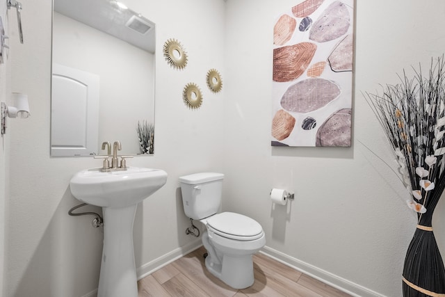 bathroom featuring hardwood / wood-style floors and toilet