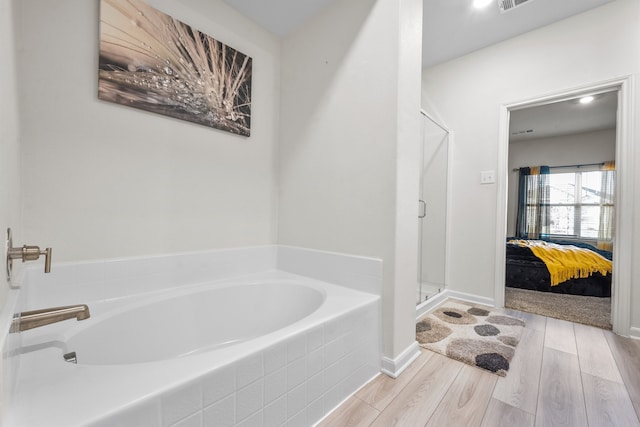 bathroom featuring hardwood / wood-style floors and independent shower and bath