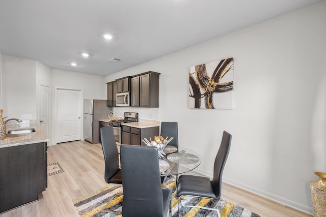 dining room with light hardwood / wood-style flooring and sink