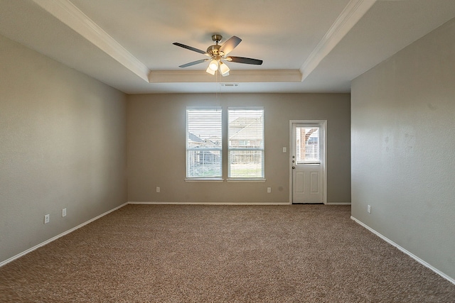 spare room with crown molding, a raised ceiling, and carpet floors