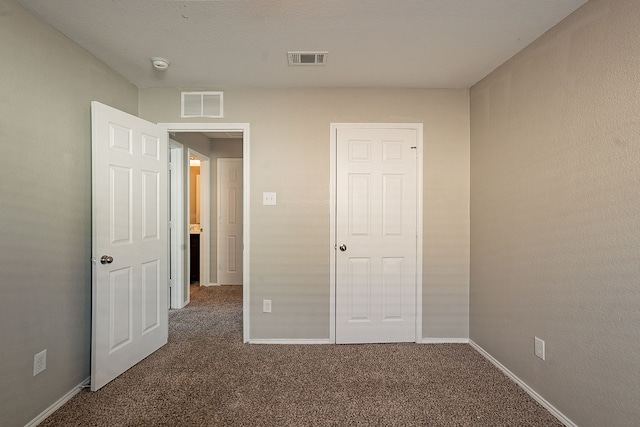 unfurnished bedroom with dark carpet