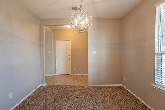 carpeted empty room with a chandelier