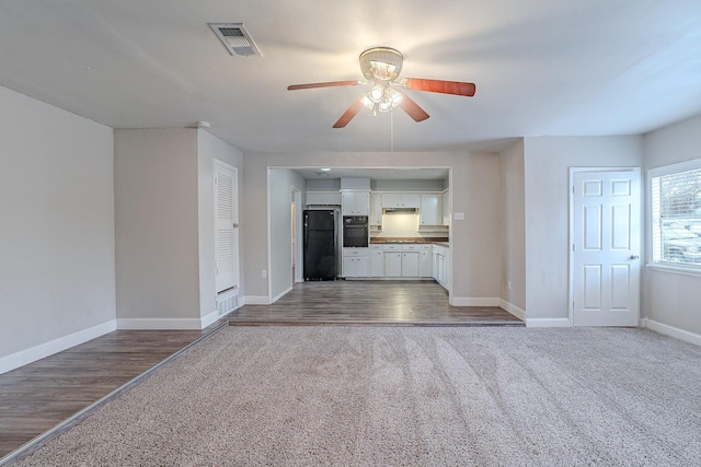 unfurnished living room featuring ceiling fan and carpet floors