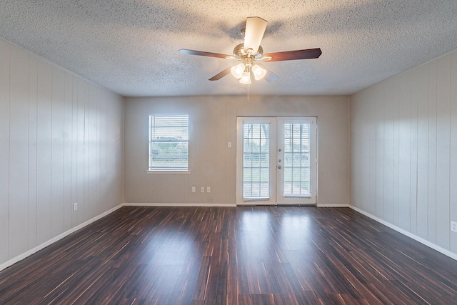 empty room with dark hardwood / wood-style floors, french doors, and a healthy amount of sunlight