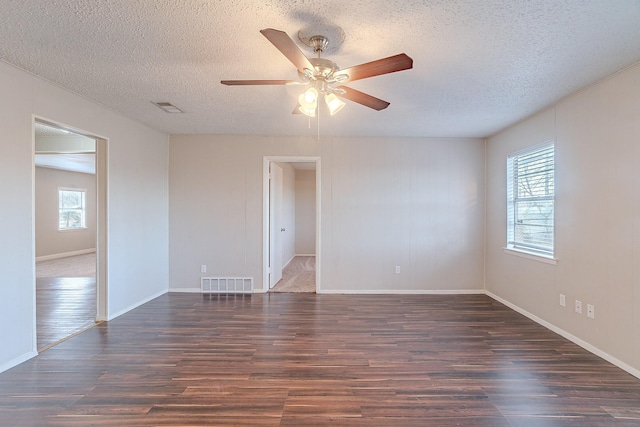 spare room with a textured ceiling, ceiling fan, and dark hardwood / wood-style flooring