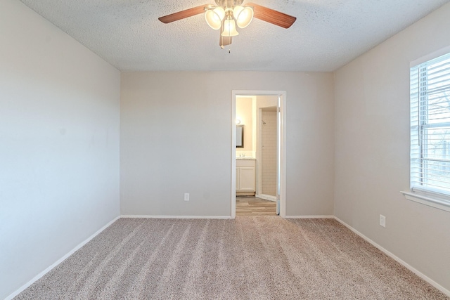 carpeted spare room with ceiling fan and a textured ceiling