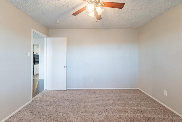 spare room featuring a textured ceiling, ceiling fan, and carpet flooring