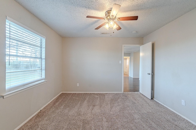 empty room featuring a textured ceiling, ceiling fan, and carpet floors