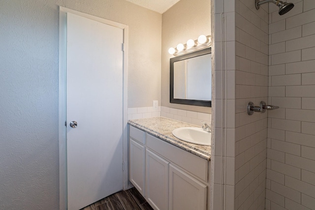 bathroom featuring vanity, tiled shower, and hardwood / wood-style flooring