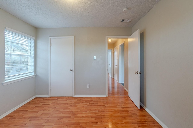 unfurnished bedroom featuring a textured ceiling and light hardwood / wood-style flooring