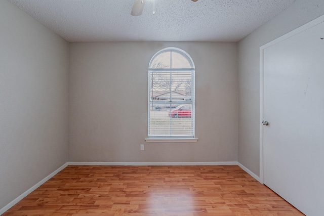 empty room featuring ceiling fan, a textured ceiling, and light hardwood / wood-style flooring