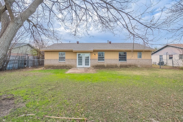 rear view of house with a yard and french doors