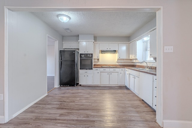 kitchen featuring a textured ceiling, sink, white cabinets, and black appliances