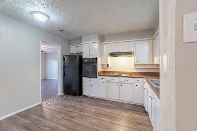 kitchen featuring black appliances, sink, white cabinetry, light wood-type flooring, and a textured ceiling