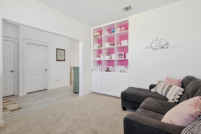 carpeted living room with built in shelves