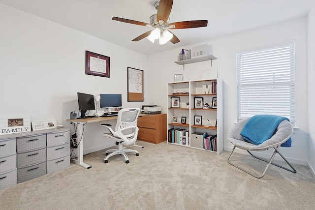 carpeted office space featuring ceiling fan