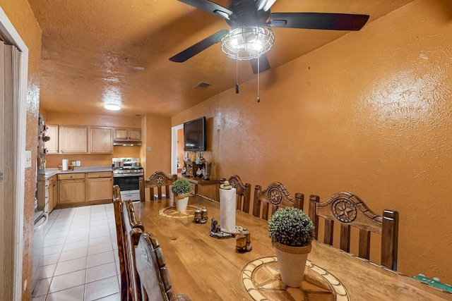 tiled dining space with ceiling fan