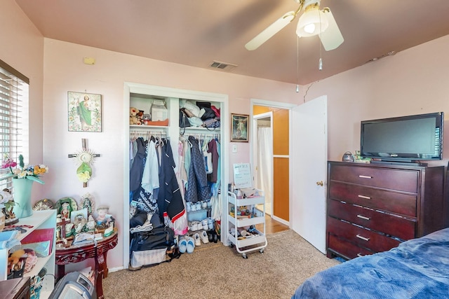 carpeted bedroom featuring ceiling fan and a closet