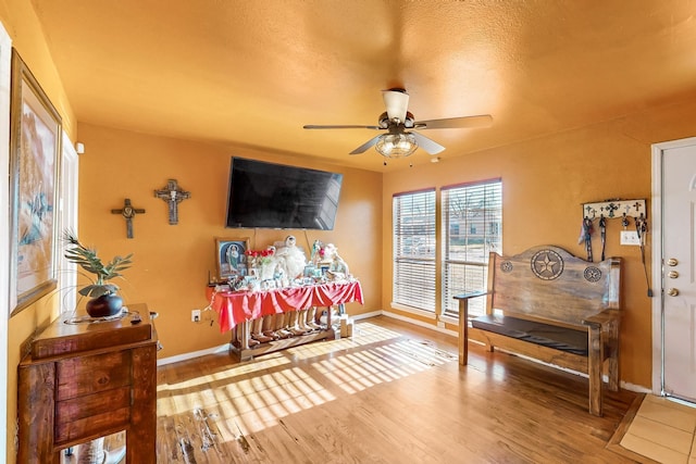 sitting room with ceiling fan and hardwood / wood-style floors