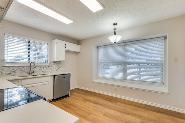 kitchen with sink, white cabinets, stainless steel dishwasher, decorative backsplash, and pendant lighting