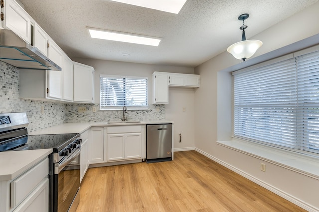 kitchen featuring stainless steel appliances, white cabinets, and hanging light fixtures