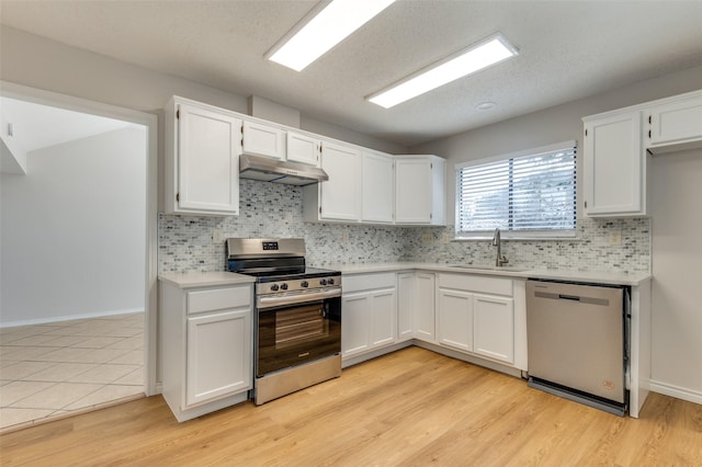 kitchen with appliances with stainless steel finishes, white cabinetry, and sink