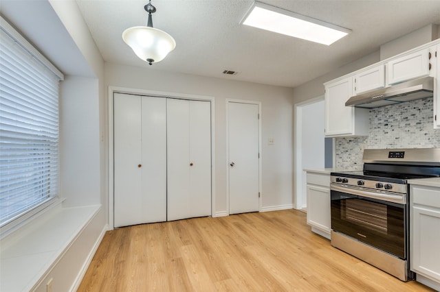 kitchen featuring decorative light fixtures, decorative backsplash, light wood-type flooring, white cabinets, and stainless steel range with electric stovetop