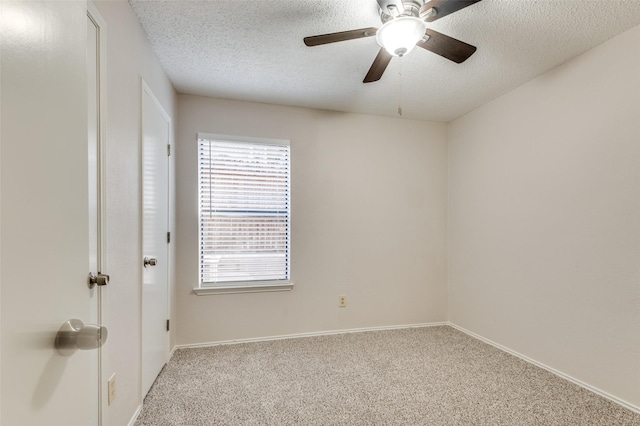 carpeted spare room featuring a textured ceiling and ceiling fan